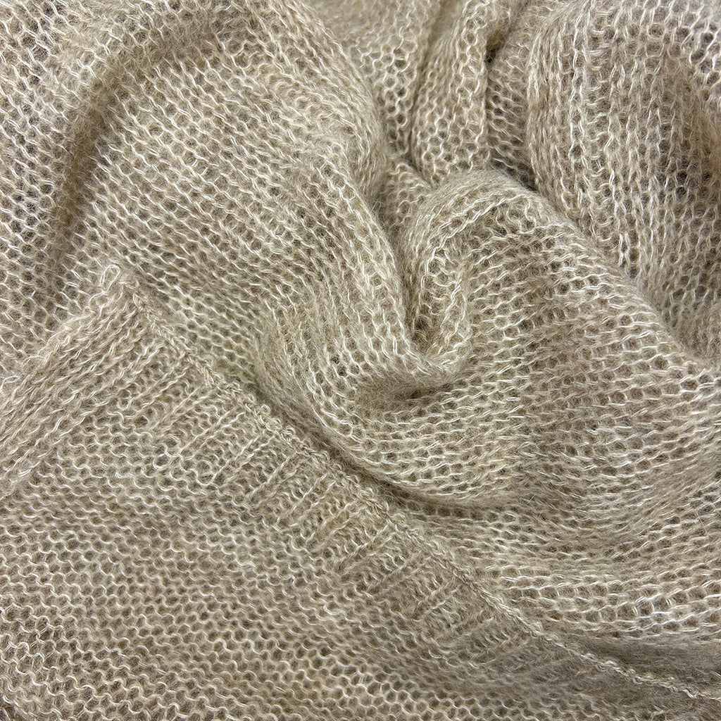 Close-up of Soft beige alpaca and merino blend scarf with subtle knit texture