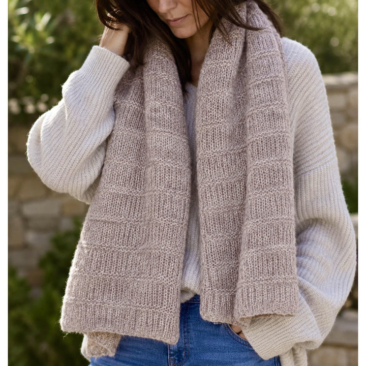 Dusty mauve, pink, gray and neutral tones alpaca blend scarf worn on a model, with heathered; alternating open knit