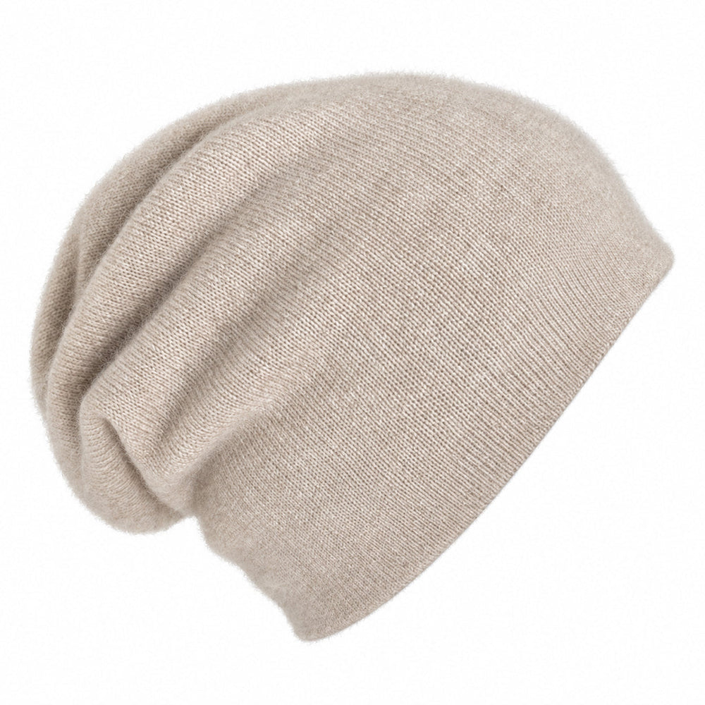 A slouchy knit cashmere beanie  in a light beige, shown against a plain white background.